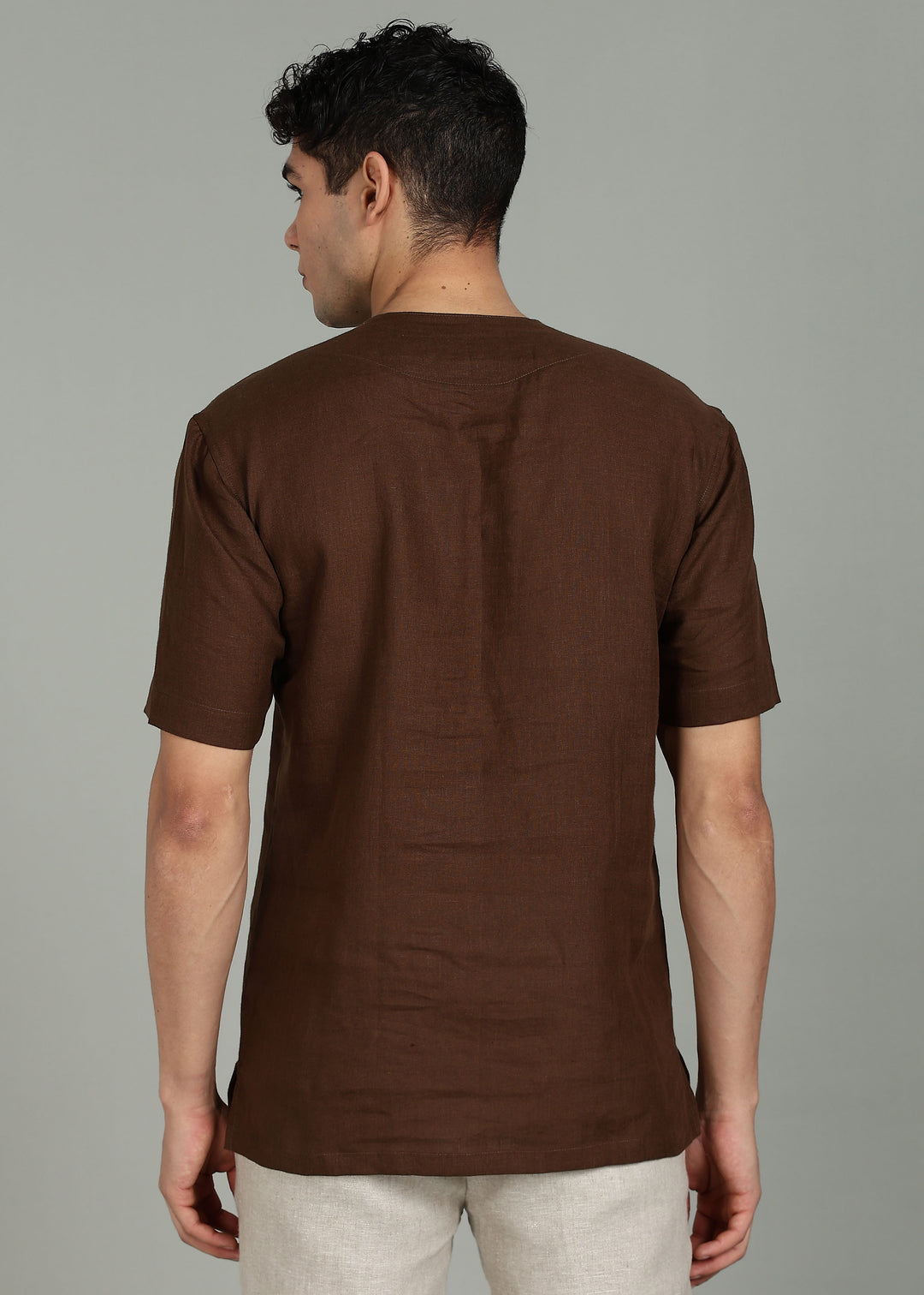 Man wearing 100% 60 LEA Coffee Brown Baseball collar T - Shirt in an indoor grey background.