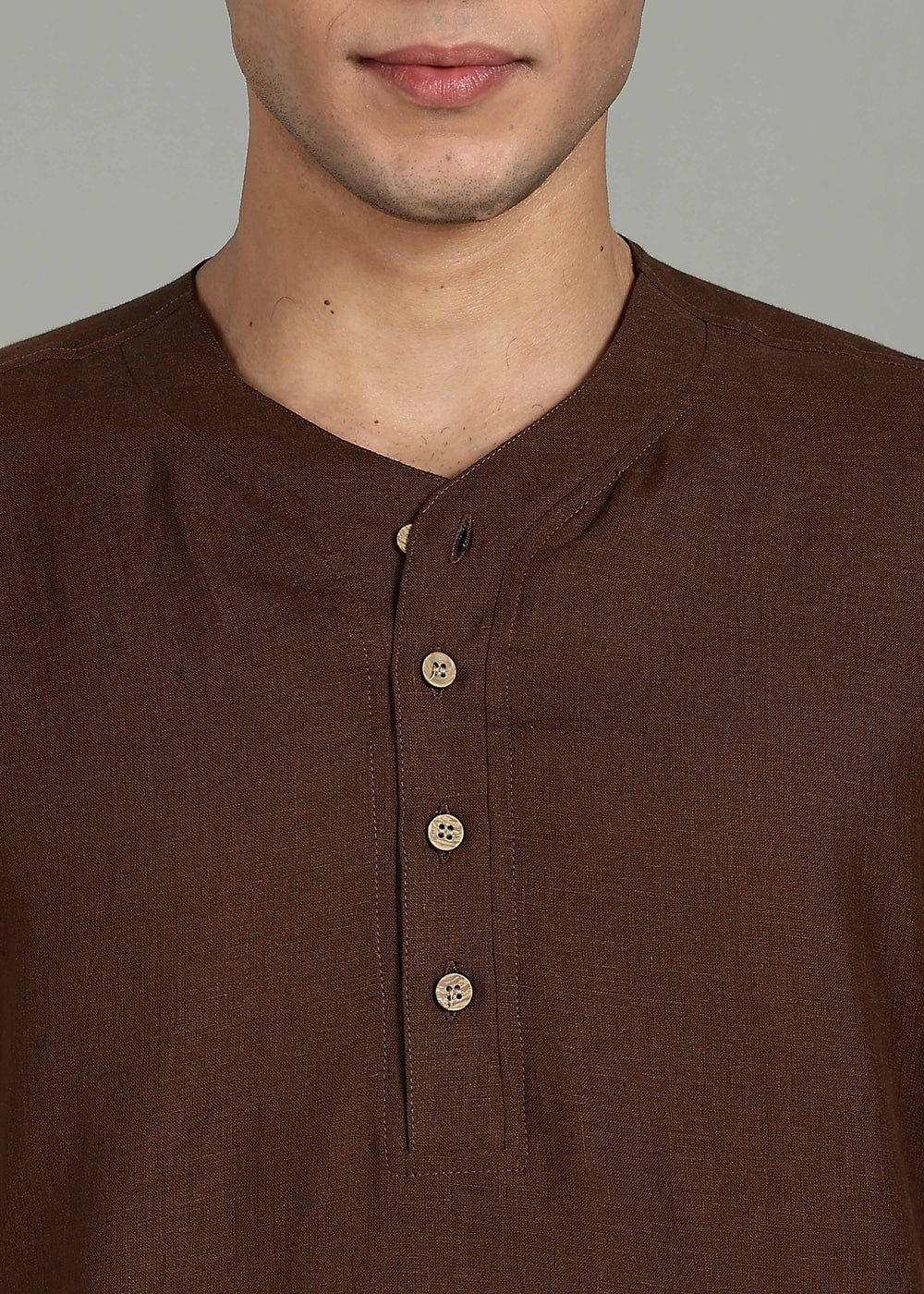 Man wearing 100% 60 LEA Coffee Brown Baseball collar T - Shirt in an indoor grey background.