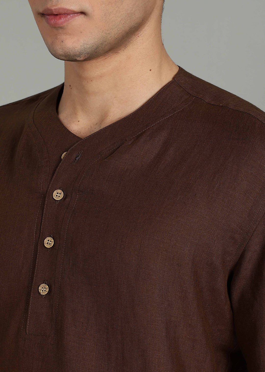 Man wearing 100% 60 LEA Coffee Brown Baseball collar T - Shirt in an indoor grey background.