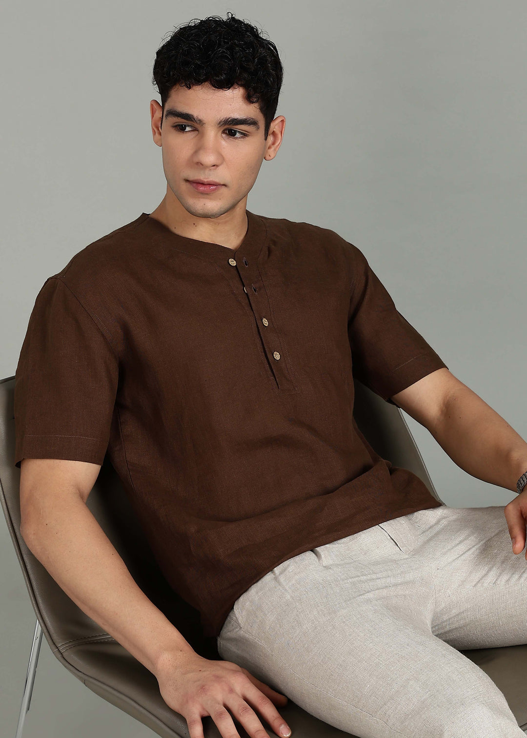 Man wearing 100% 60 LEA Coffee Brown Baseball collar T - Shirt in an indoor grey background.