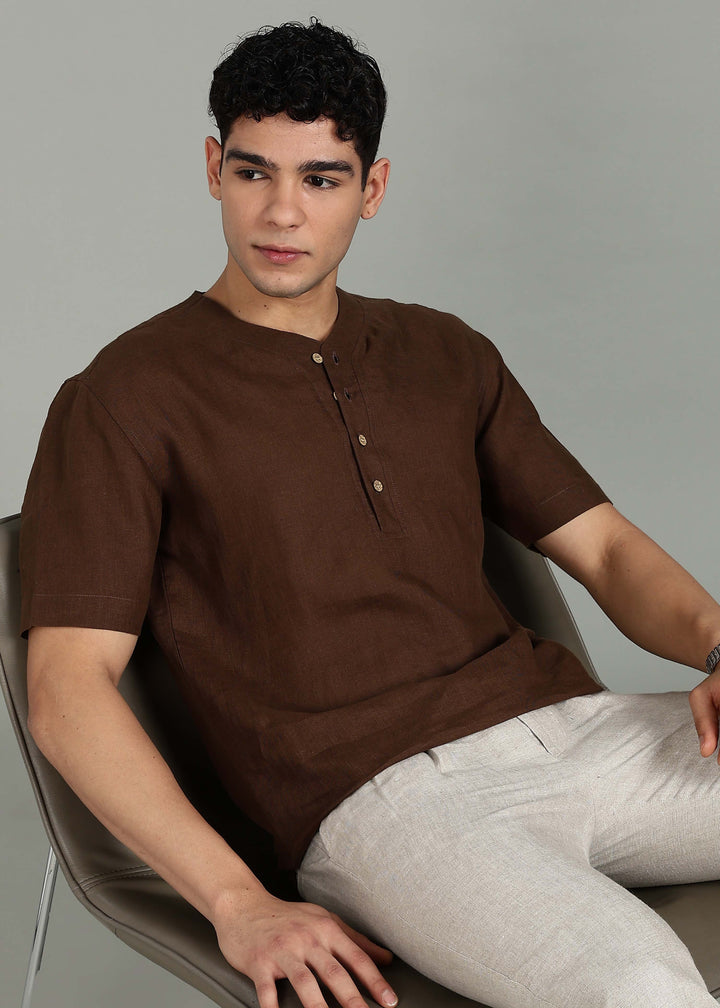 Man wearing 100% 60 LEA Coffee Brown Baseball collar T - Shirt in an indoor grey background.