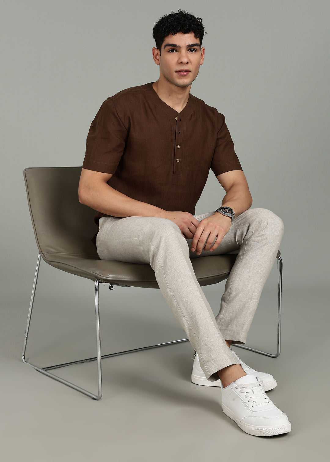 Man wearing 100% 60 LEA Coffee Brown Baseball collar T - Shirt in an indoor grey background.