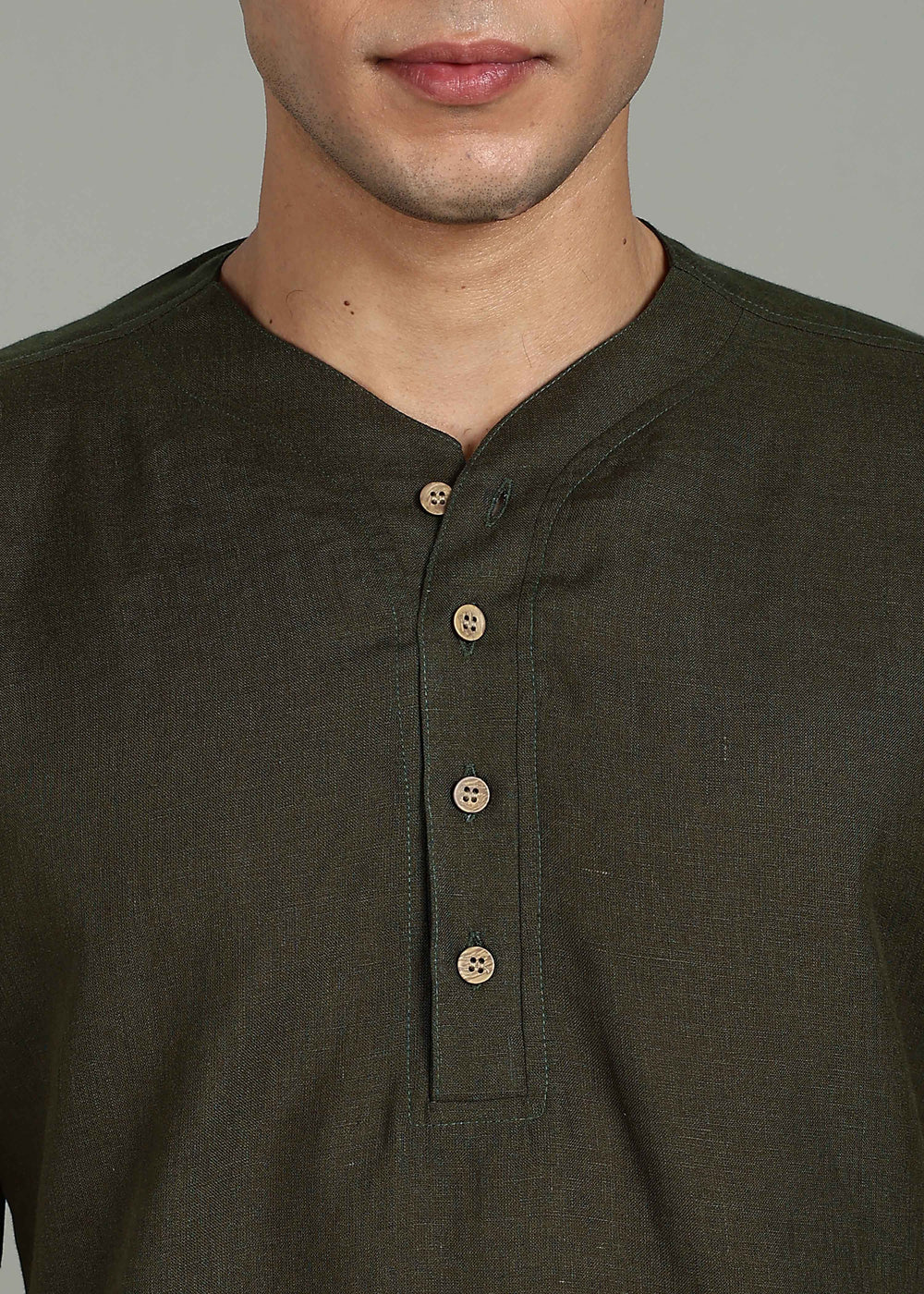Man wearing 100% 60 LEA Moss Green Baseball collar T - Shirt in an indoor grey background.