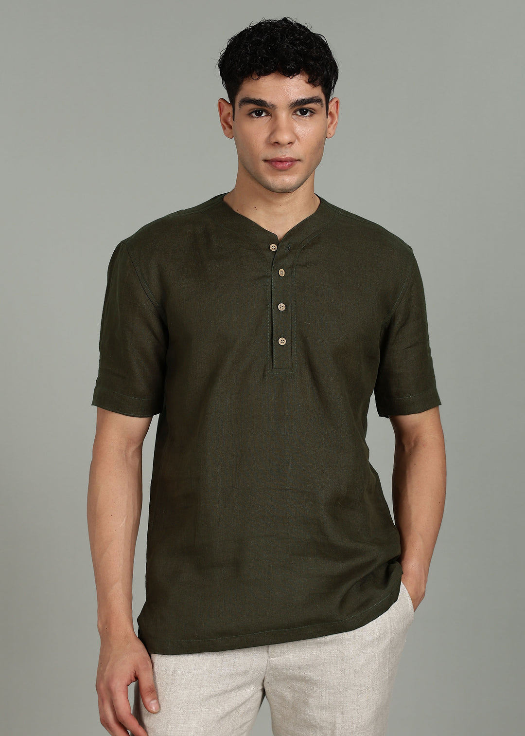 Man wearing 100% 60 LEA Moss Green Baseball collar T - Shirt in an indoor grey background.