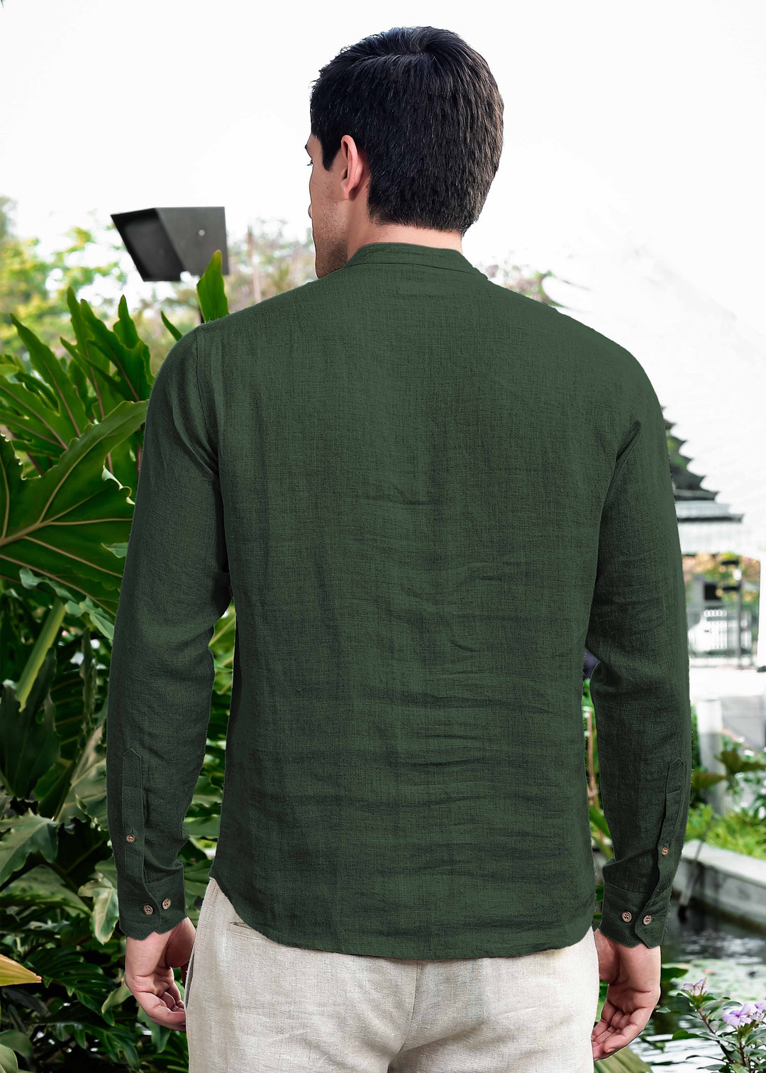 Man wearing a 100% pure linen dark fern green short kurta standing outdoors with plants in the background