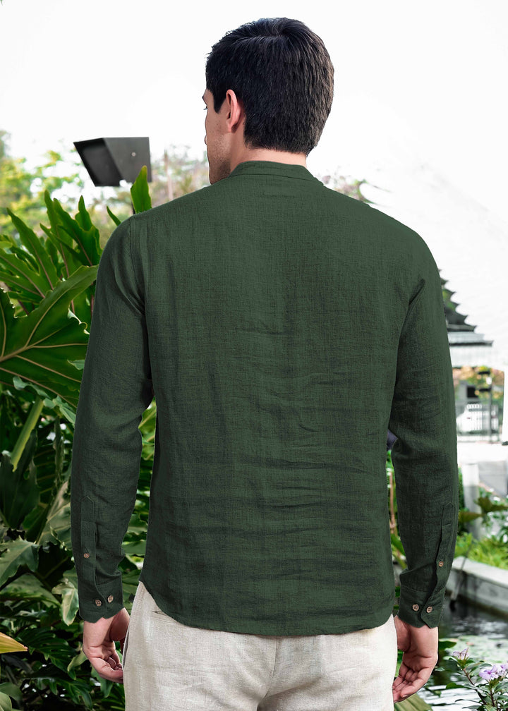 Man wearing a 100% pure linen dark fern green short kurta standing outdoors with plants in the background
