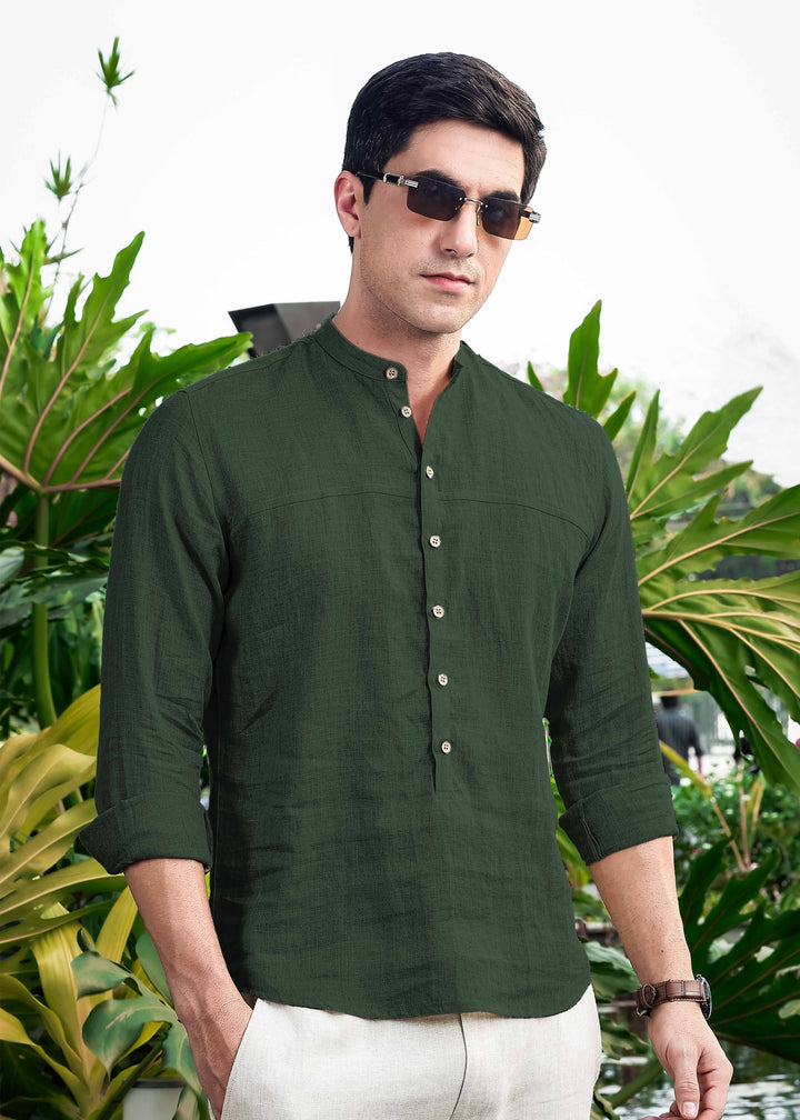 Man wearing a 100% pure linen dark fern green short kurta with sunglasses in a garden setting