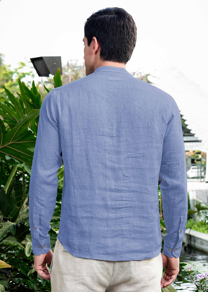 Man wearing a 100% pure linen olympic blue short kurta standing outdoors with greenery in the background