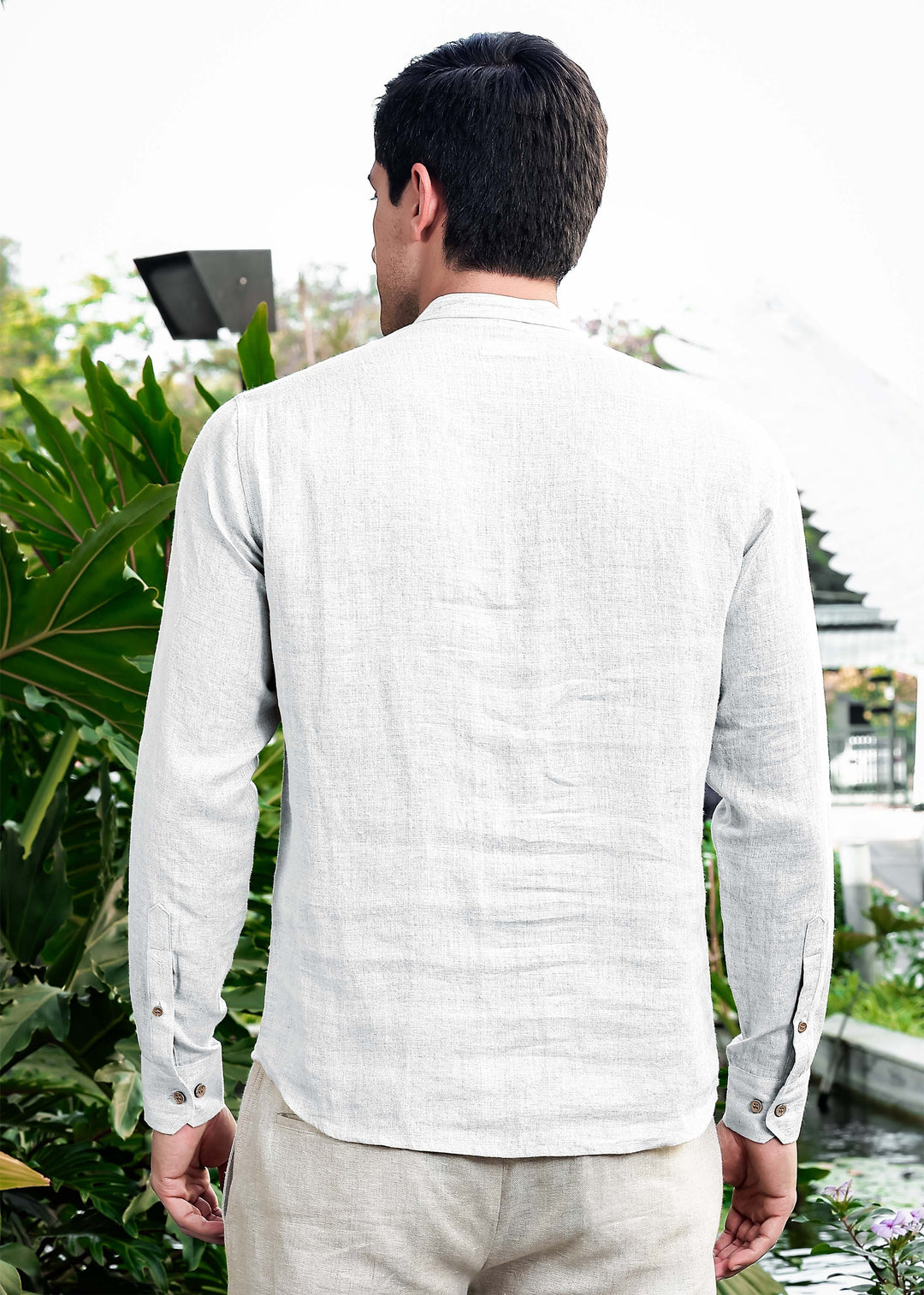 Man wearing a 100% pure linen white short kurta and pants standing outdoors with greenery in the background