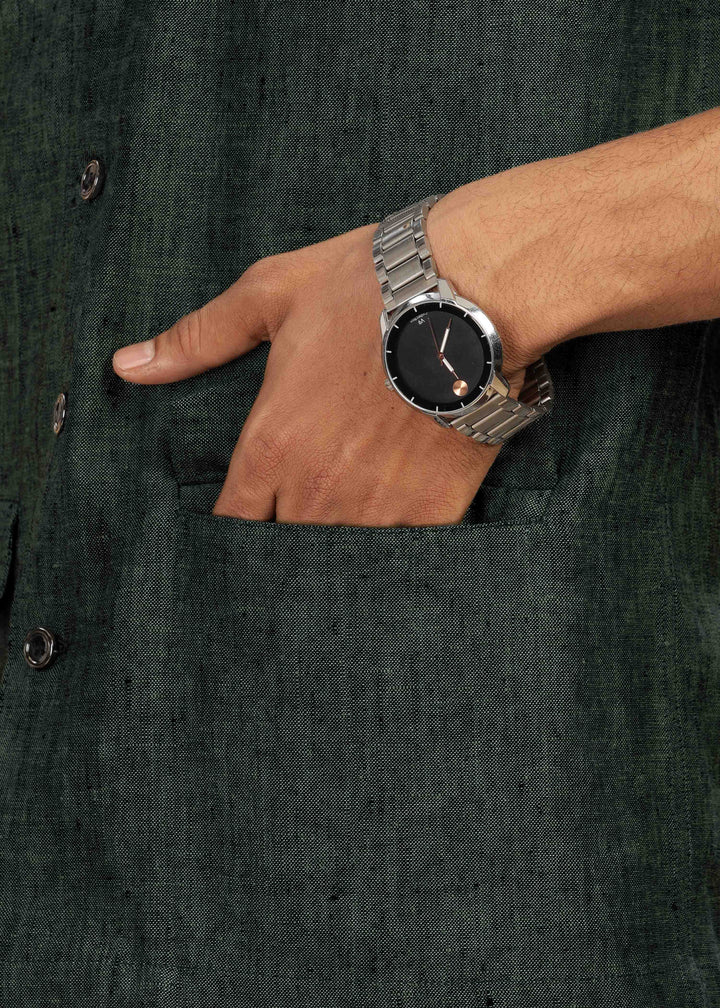 Man wearing a 100% pure linen dark green jacket in 25 LEA and sunglasses on a beige background