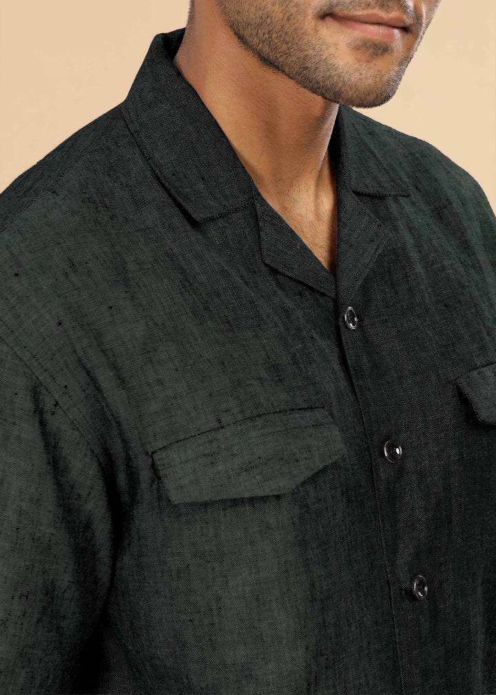 Man wearing a 100% pure linen dark green jacket in 25 LEA and sunglasses on a beige background