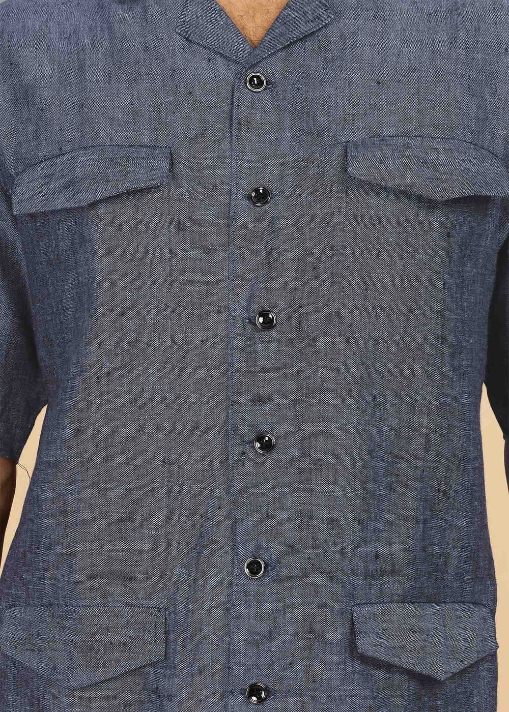Man wearing a 100% pure linen dark blue grey jacket in 25 LEA and sunglasses on a beige background