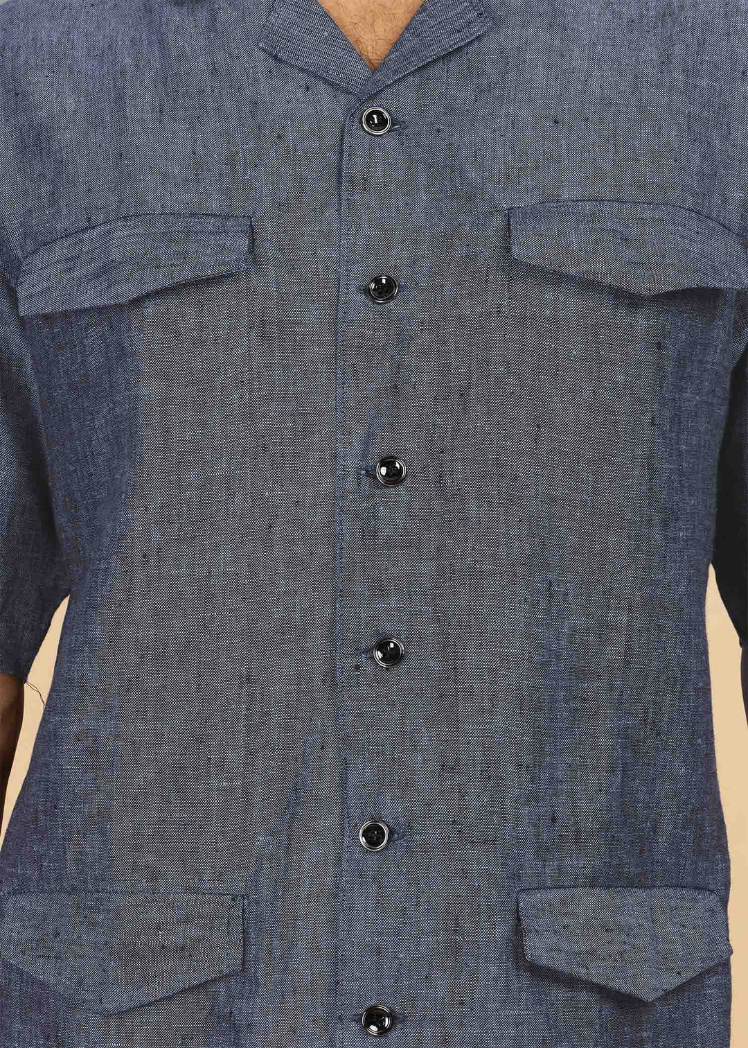 Man wearing a 100% pure linen dark blue grey jacket in 25 LEA and sunglasses on a beige background
