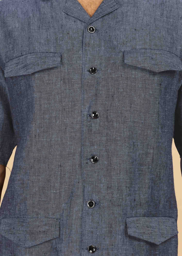 Man wearing a 100% pure linen dark blue grey jacket in 25 LEA and sunglasses on a beige background