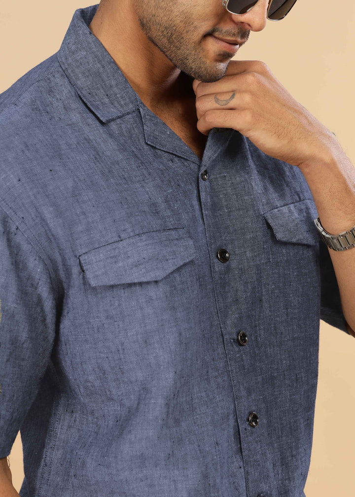 Man wearing a 100% pure linen dark blue grey jacket in 25 LEA and sunglasses on a beige background