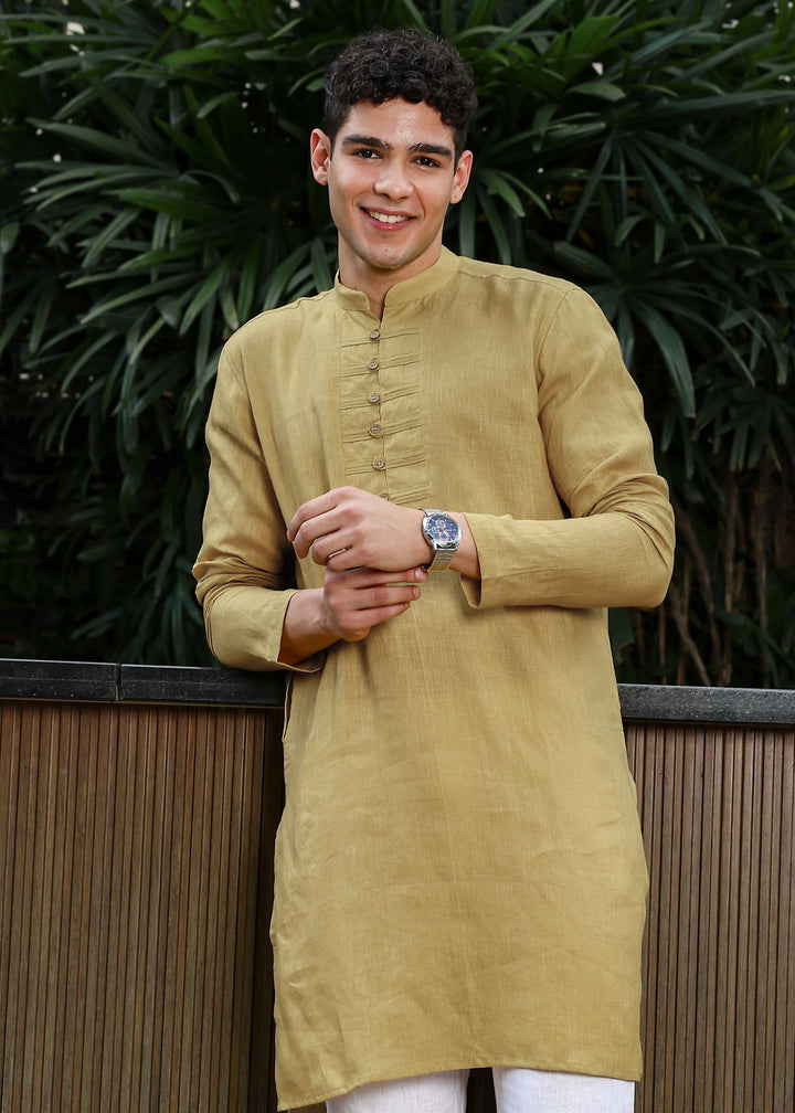 Man wearing a 100% Sunburst yellow 60 lea Kurta, with placket detail, in a Green outdoor Background.