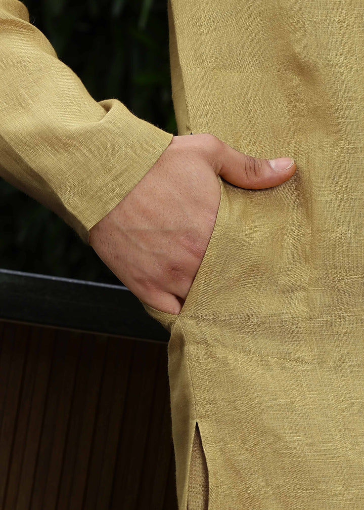 Man wearing a 100% Sunburst yellow 60 lea Kurta, with placket detail, in a Green outdoor Background.