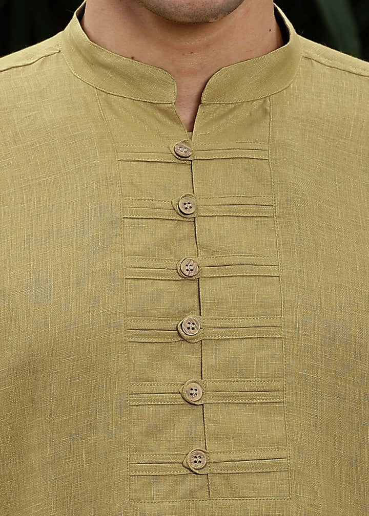 Man wearing a 100% Sunburst yellow 60 lea Kurta, with placket detail, in a Green outdoor Background.