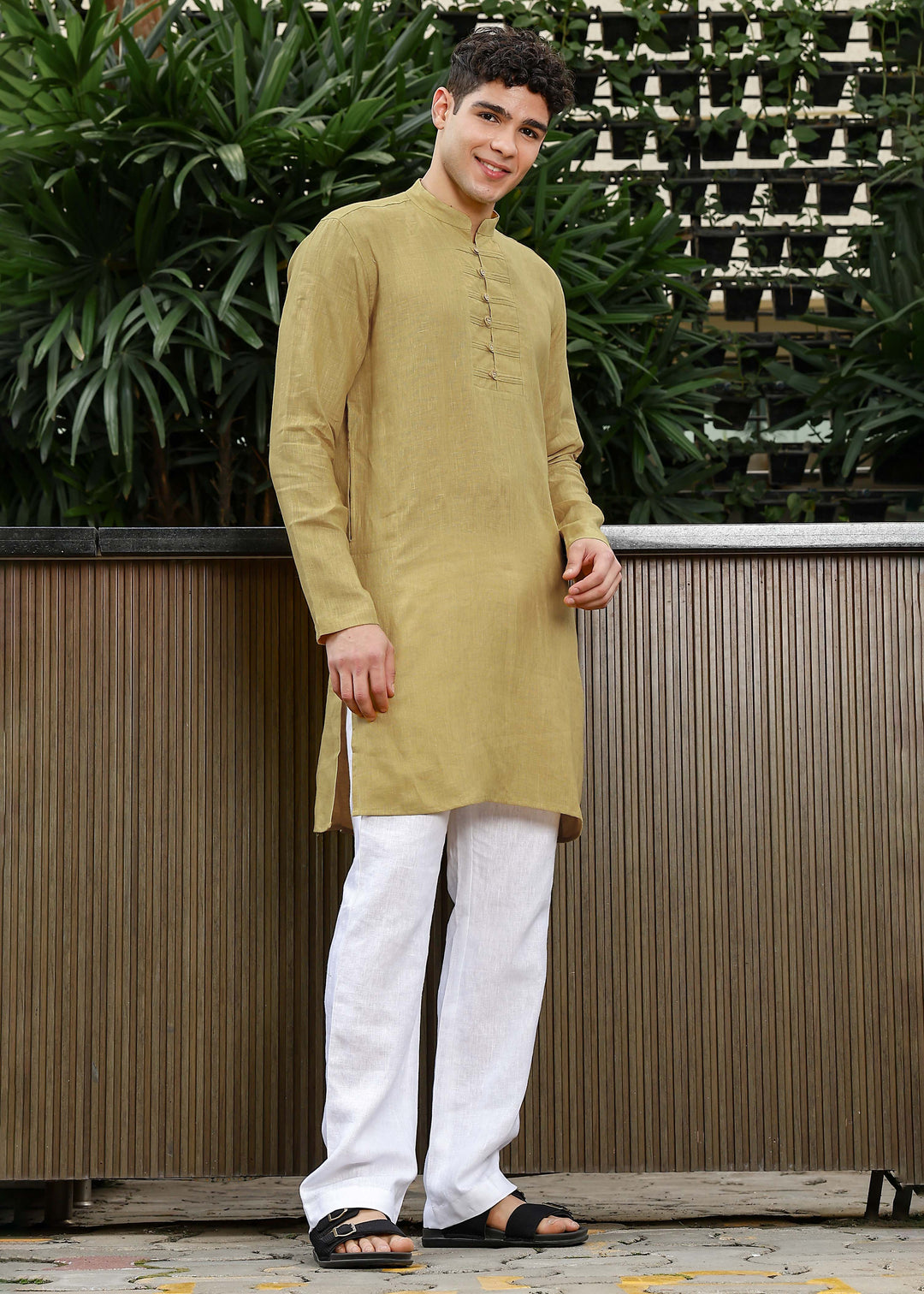Man wearing a 100% Sunburst yellow 60 lea Kurta, with placket detail, in a Green outdoor Background.