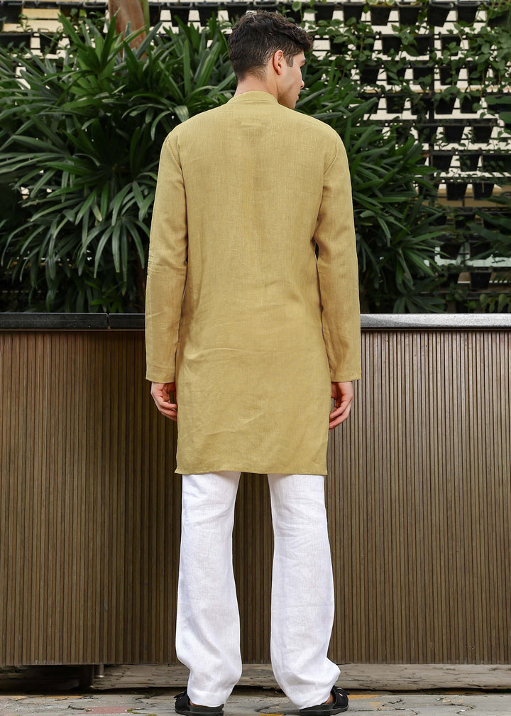 Man wearing a 100% Sunburst yellow 60 lea Kurta, with placket detail, in a Green outdoor Background.