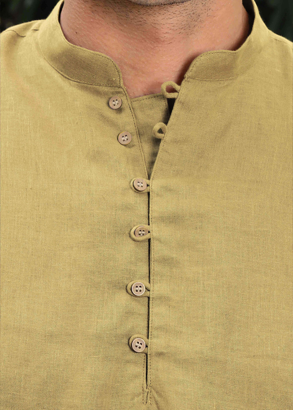 Man wearing a 100% pure linen 60 LEA sunburst yellow kurta against a green leafy background