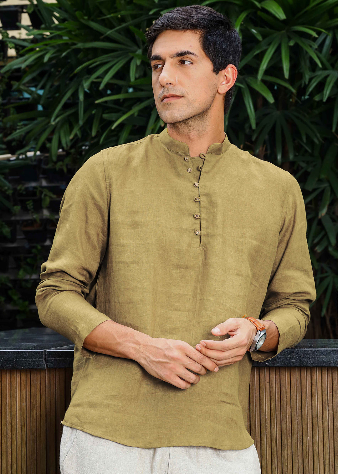 Man wearing a 100% pure linen 60 LEA sunburst yellow kurta against a green leafy background
