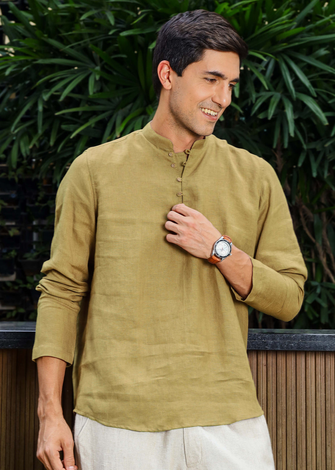 Man wearing a 100% pure linen 60 LEA sunburst yellow kurta against a green leafy background