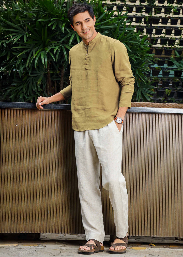 Man wearing a 100% pure linen 60 LEA sunburst yellow kurta against a green leafy background