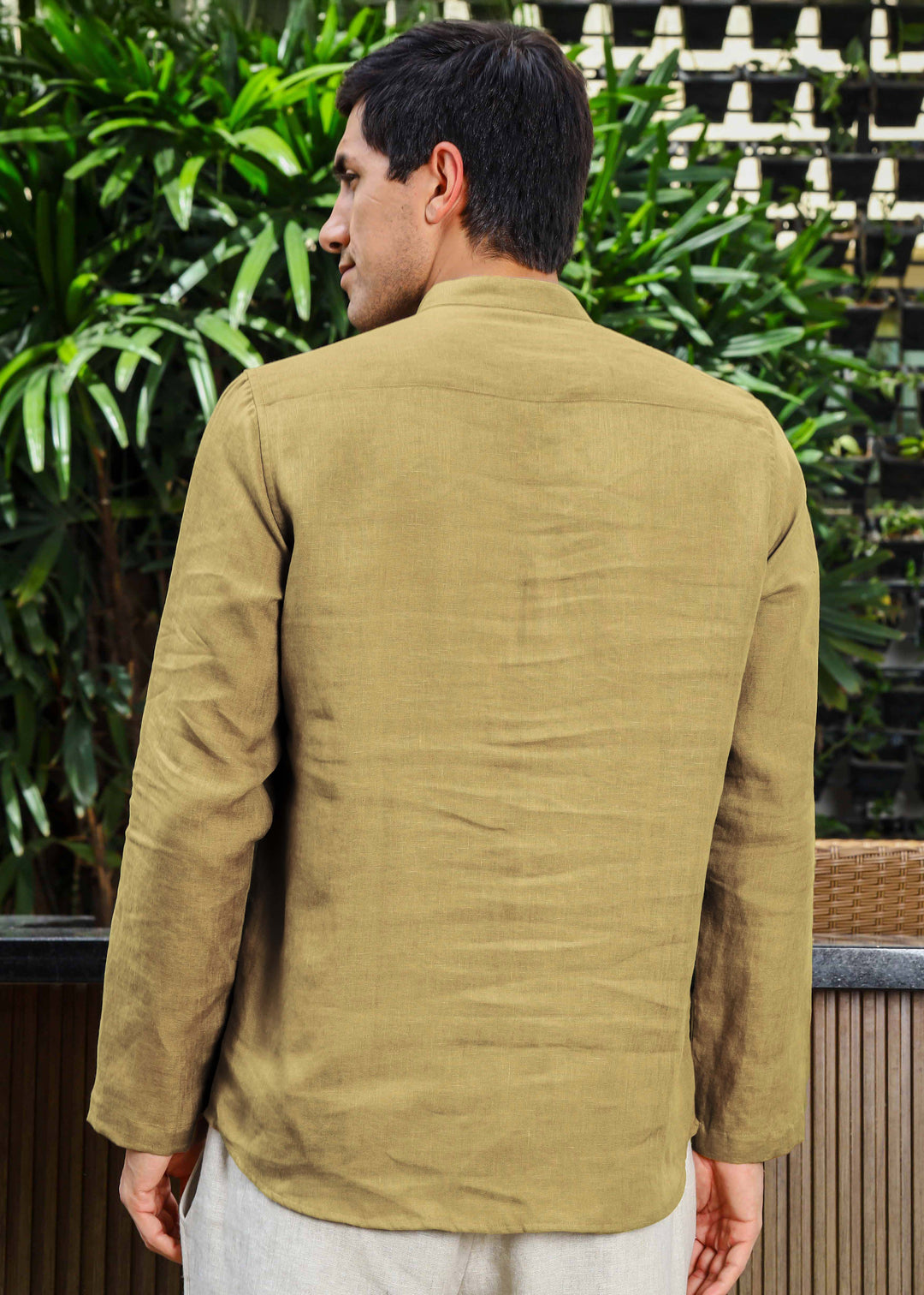 Man wearing a 100% pure linen 60 LEA sunburst yellow kurta against a green leafy background