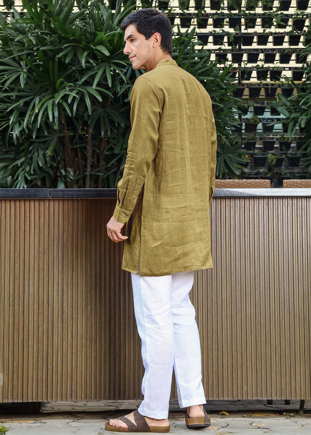 Man wearing a 100% pure linen 60 LEA sunburst yellow kurta against a green leafy background