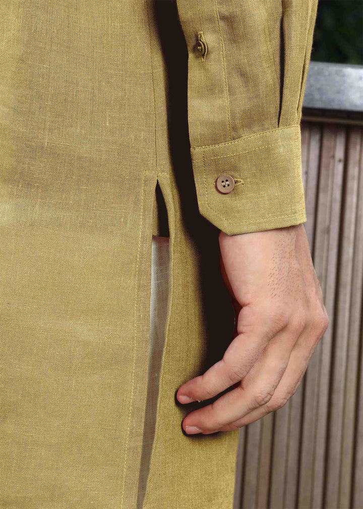 Man wearing a 100% pure linen 60 LEA sunburst yellow kurta against a green leafy background