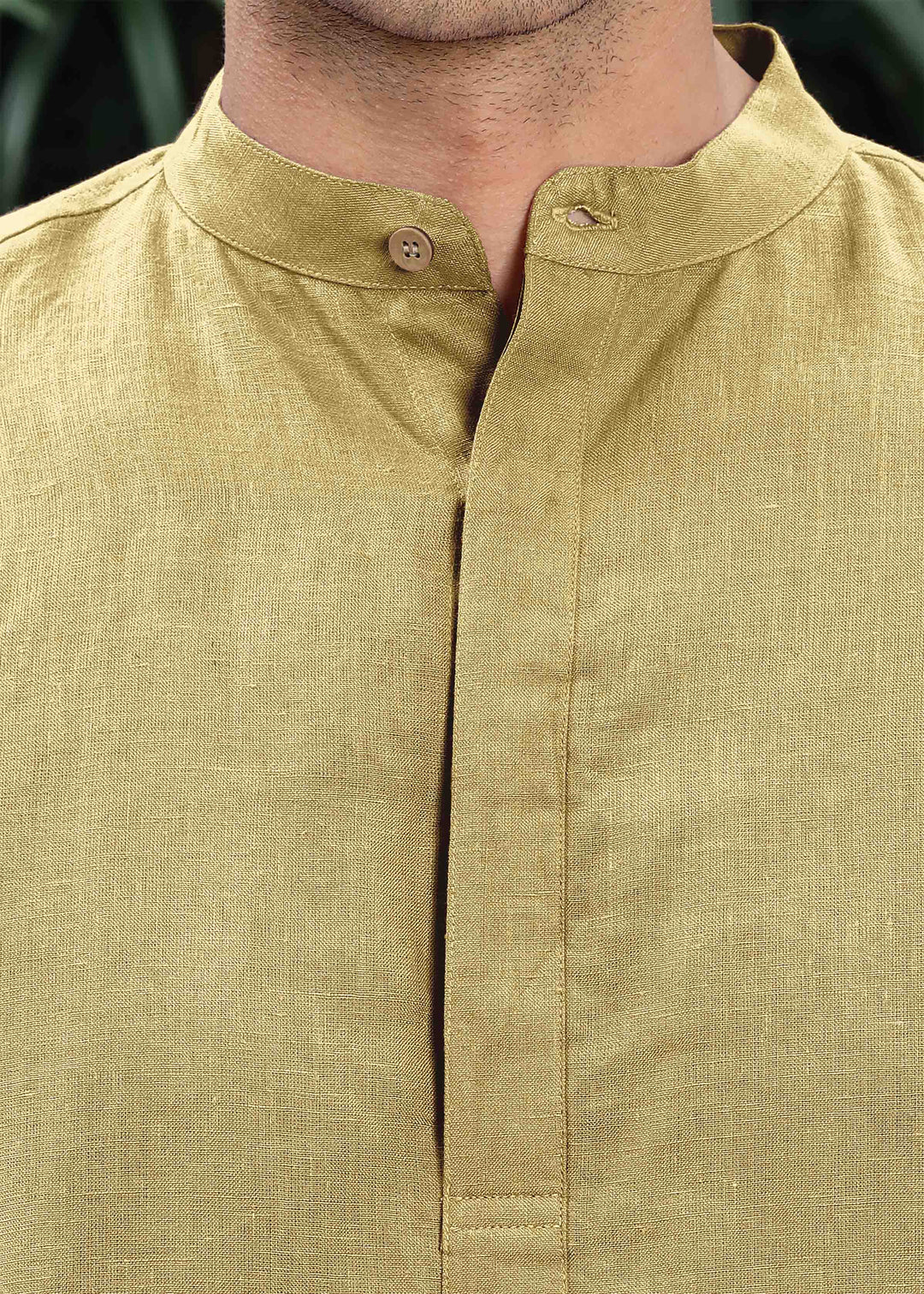 Man wearing a 100% pure linen 60 LEA sunburst yellow kurta against a green leafy background