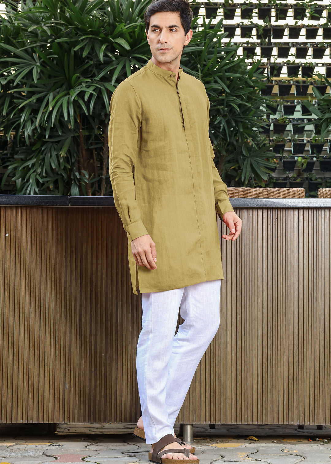 Man wearing a 100% pure linen 60 LEA sunburst yellow kurta against a green leafy background