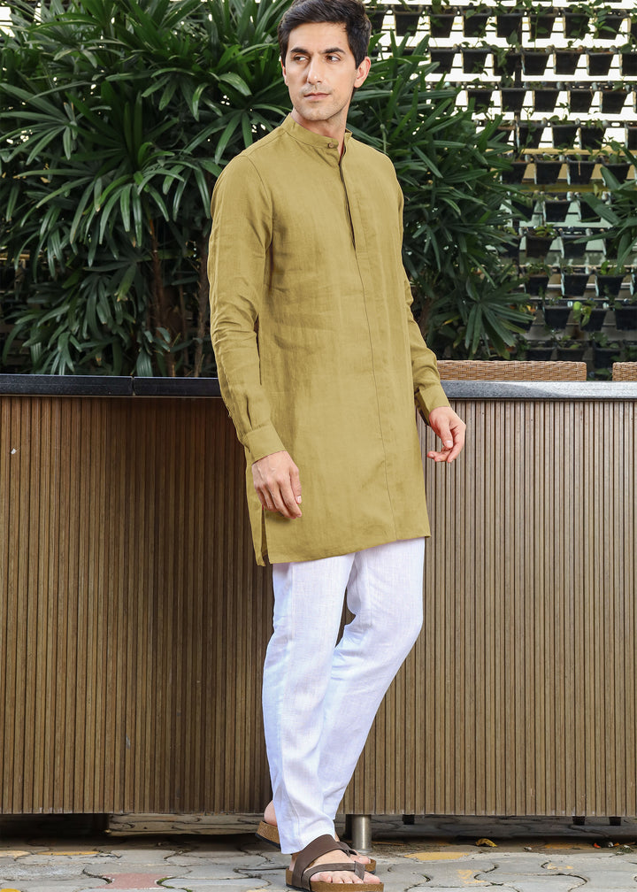 Man wearing a 100% pure linen 60 LEA sunburst yellow kurta against a green leafy background