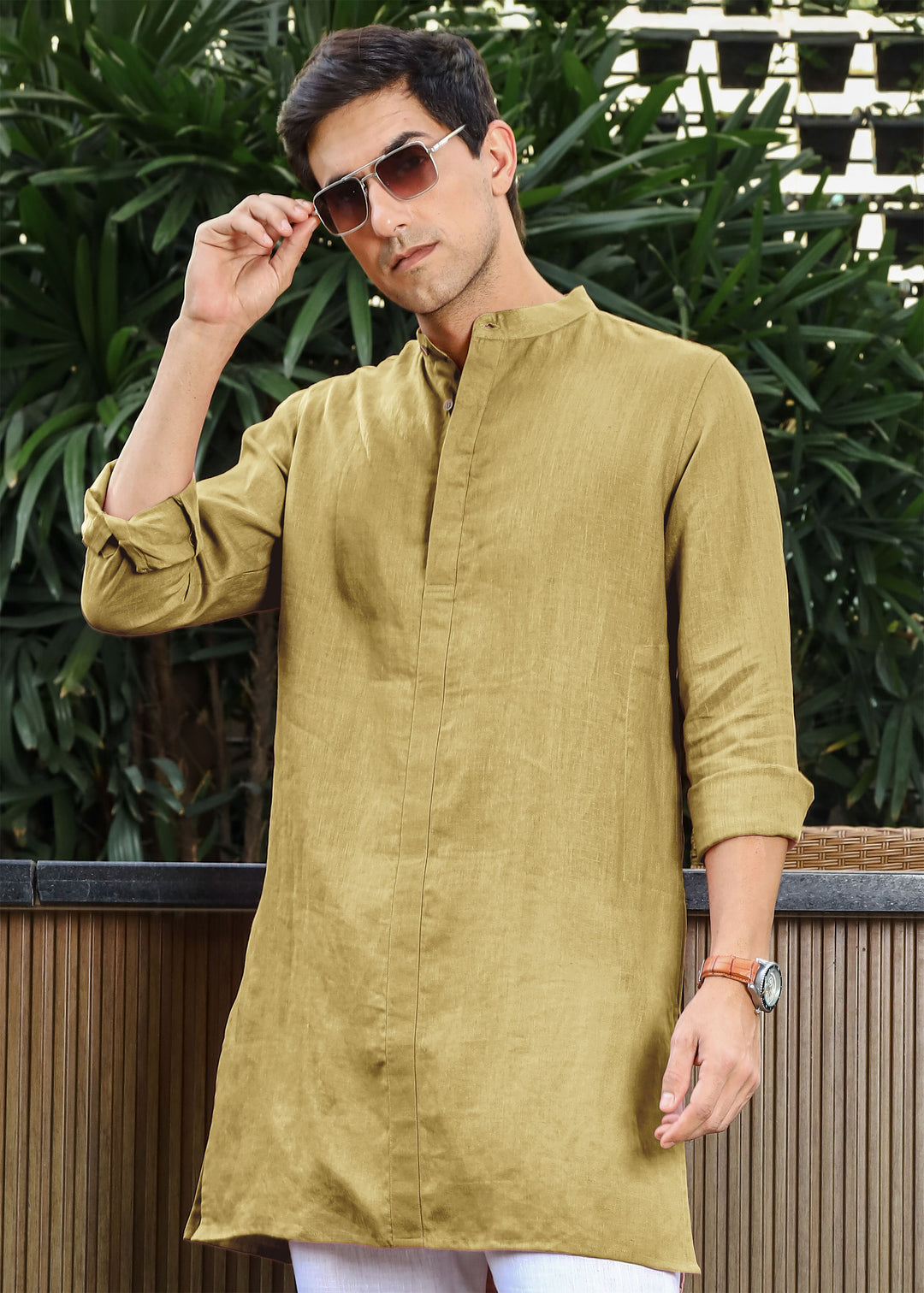 Man wearing a 100% pure linen 60 LEA sunburst yellow kurta against a green leafy background