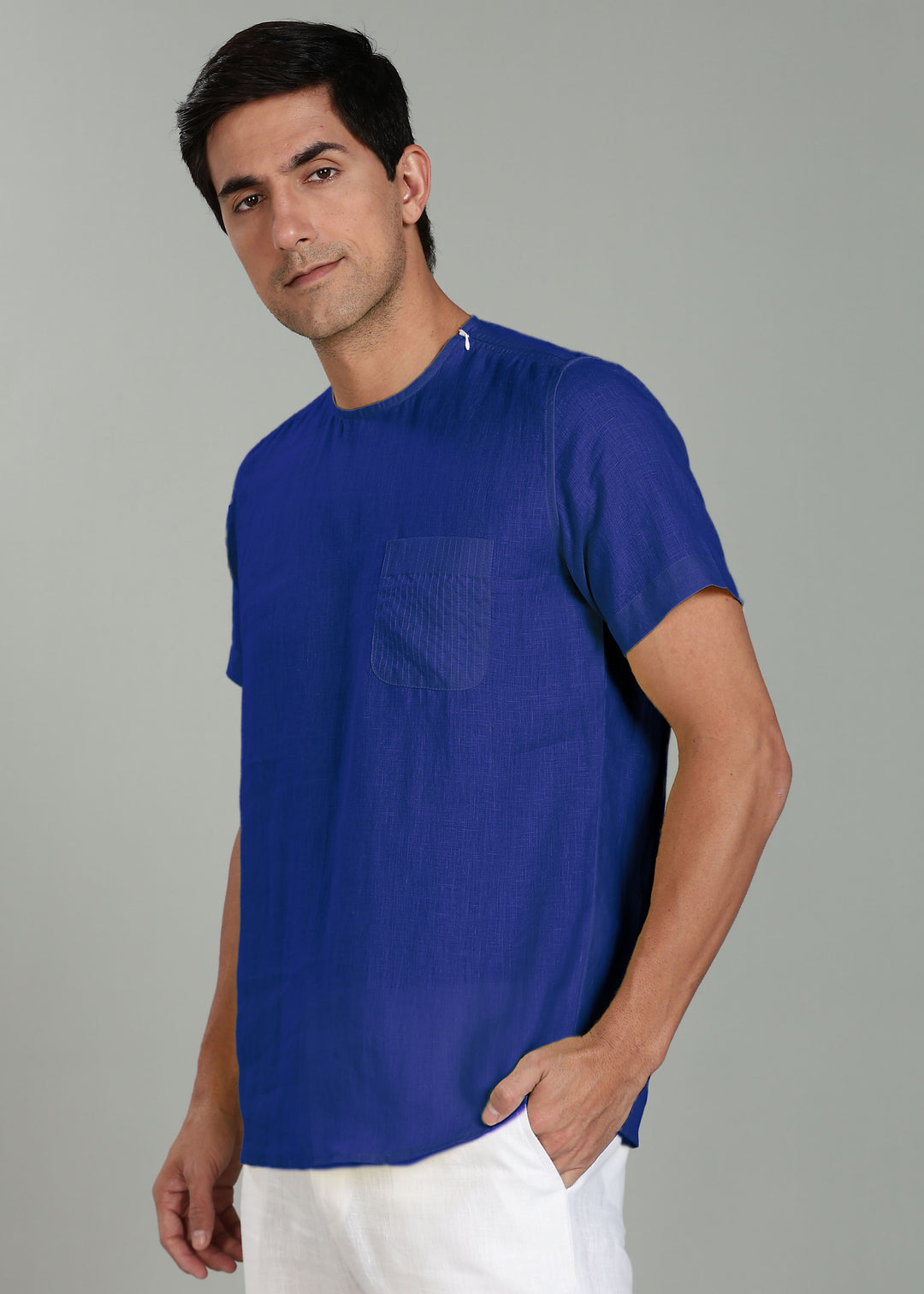 Man wearing a 100% pure linen egyptian blue t-shirt against a gray background
