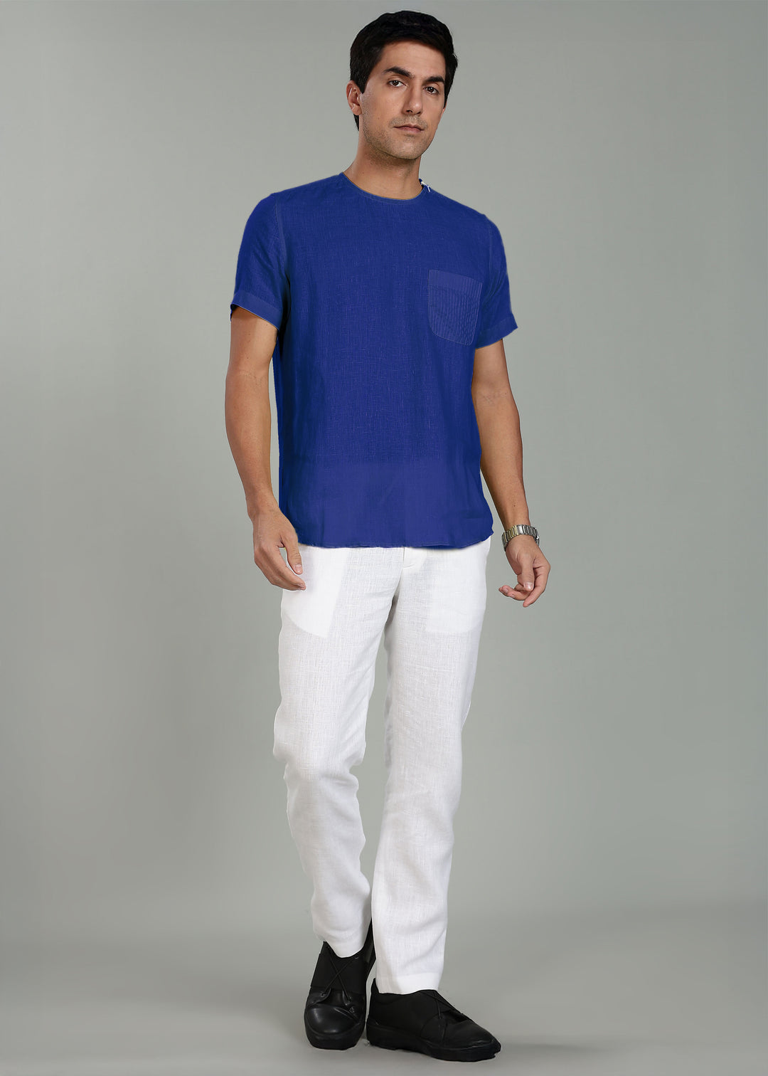 Man wearing a 100% pure linen egyptian blue t-shirt  and white pants on a gray background