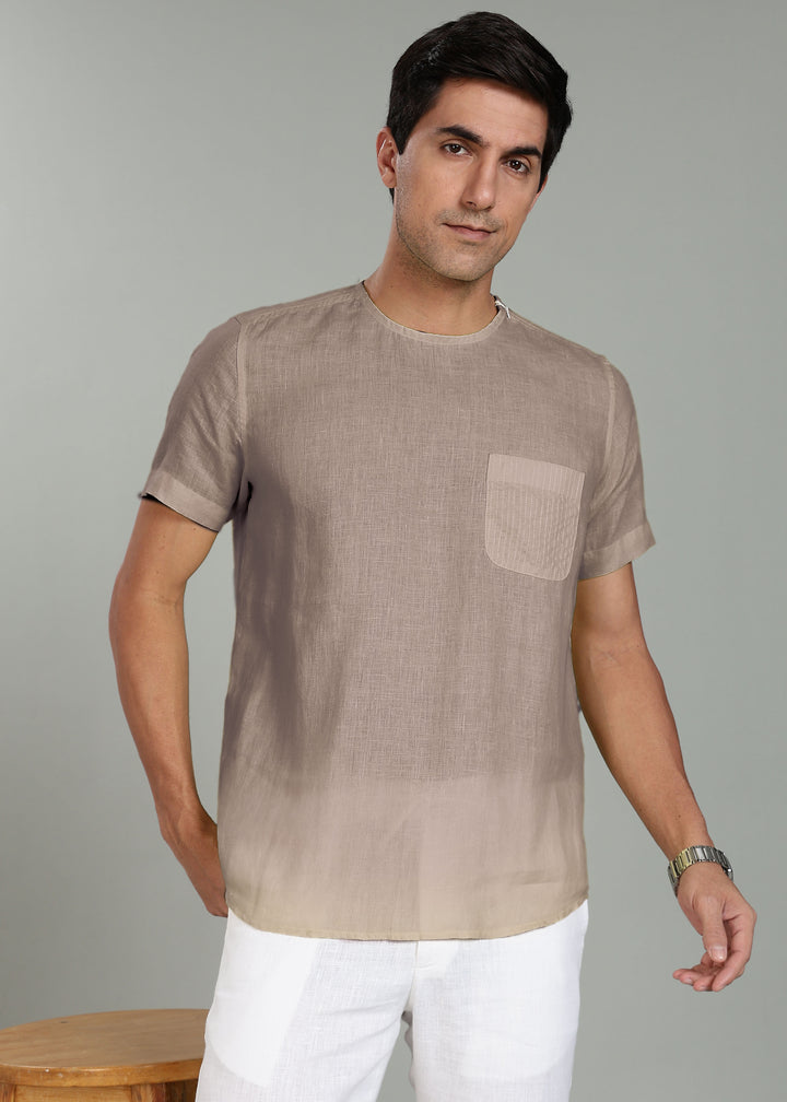 Man wearing a 100% pure linen fawn pink t-shirt with a pocket against a gray background