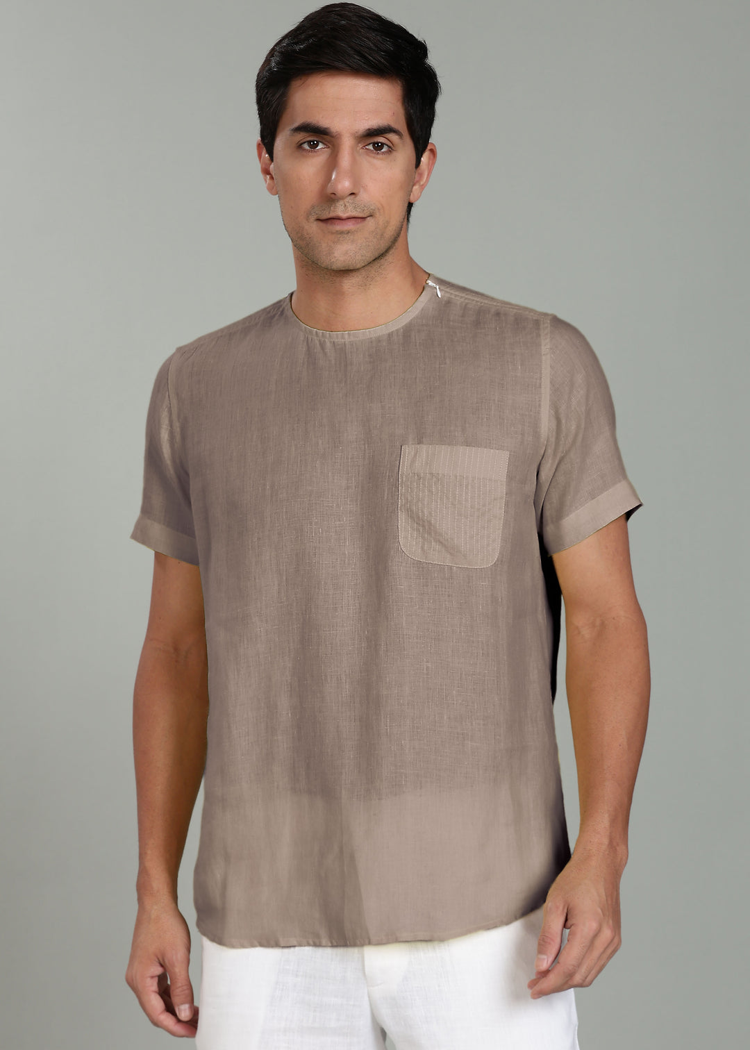 Man wearing a 100% pure linen fawn pink t-shirt with a pocket on a gray background