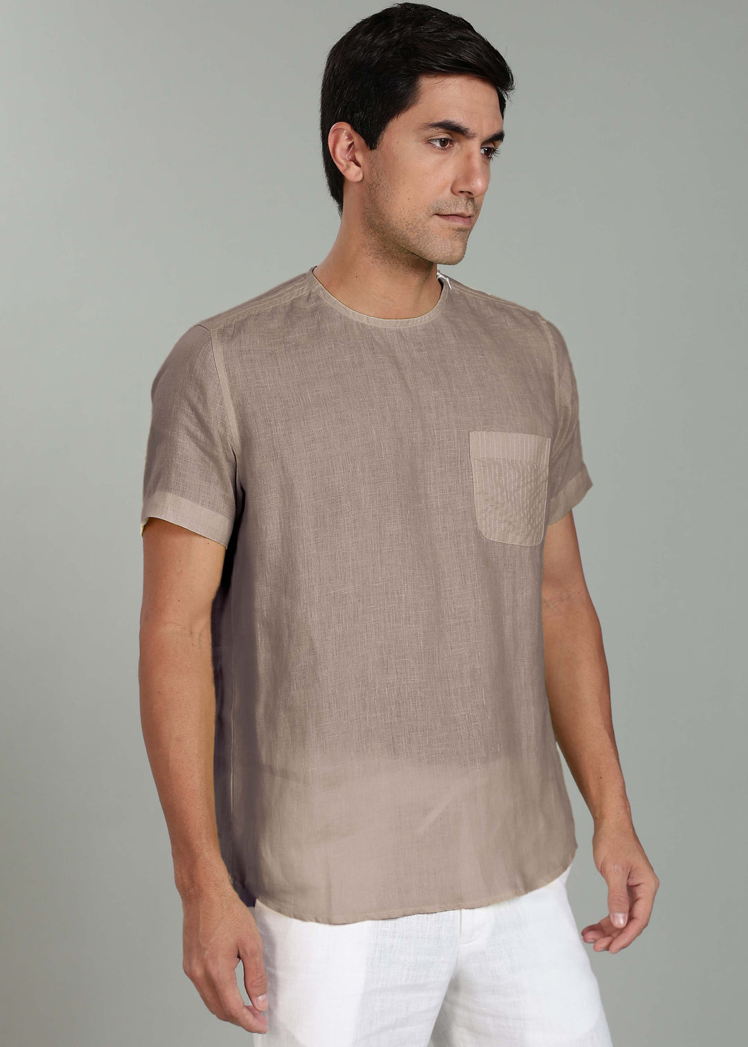 Man wearing a 100% pure linen fawn pink t-shirt with a pocket on a gray background