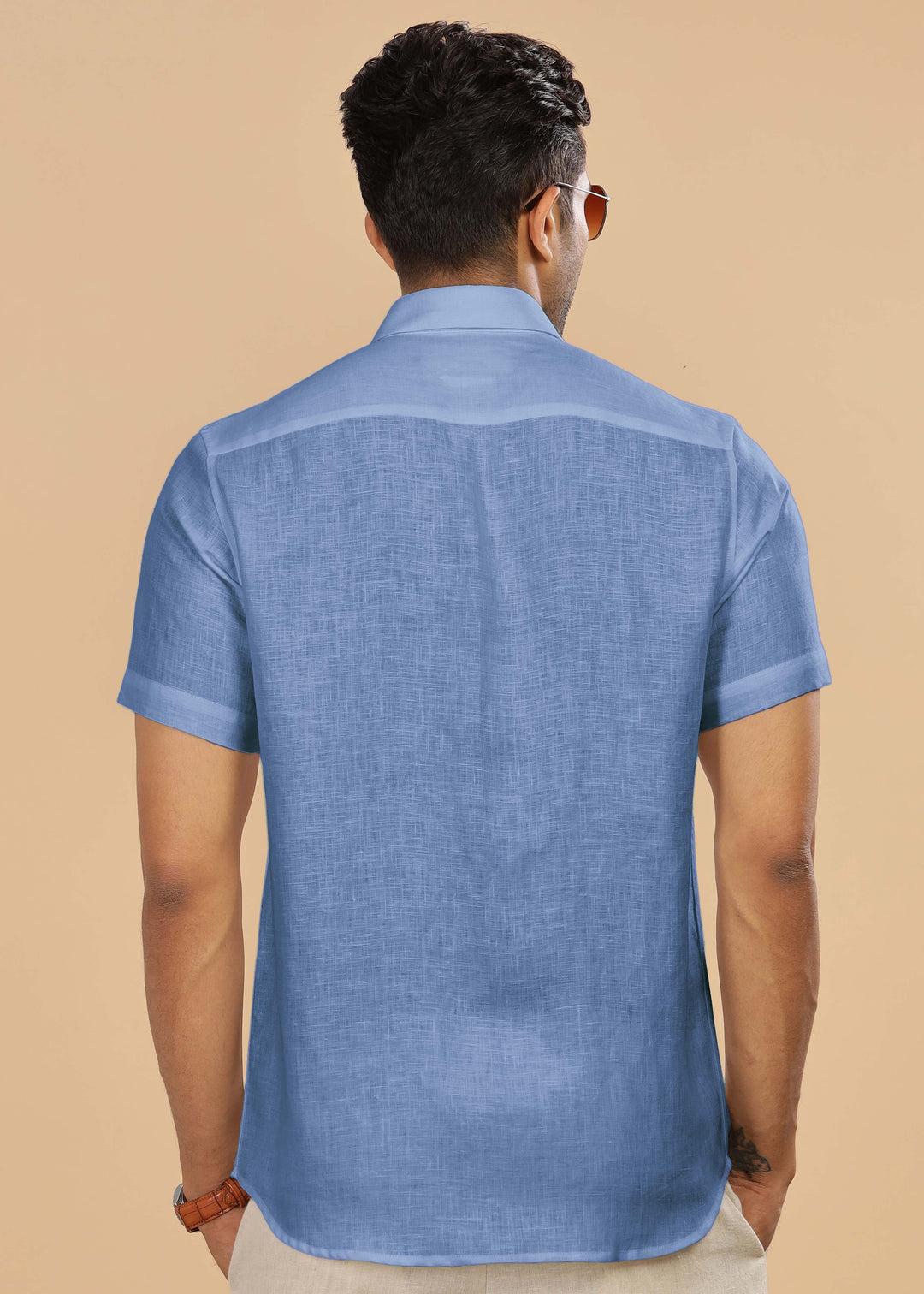 Man wearing a 100% pure linen olympic blue shirt on a beige background