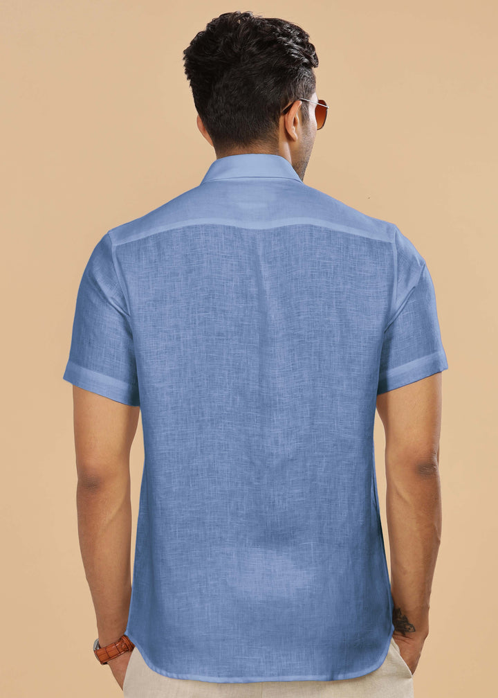 Man wearing a 100% pure linen olympic blue shirt on a beige background