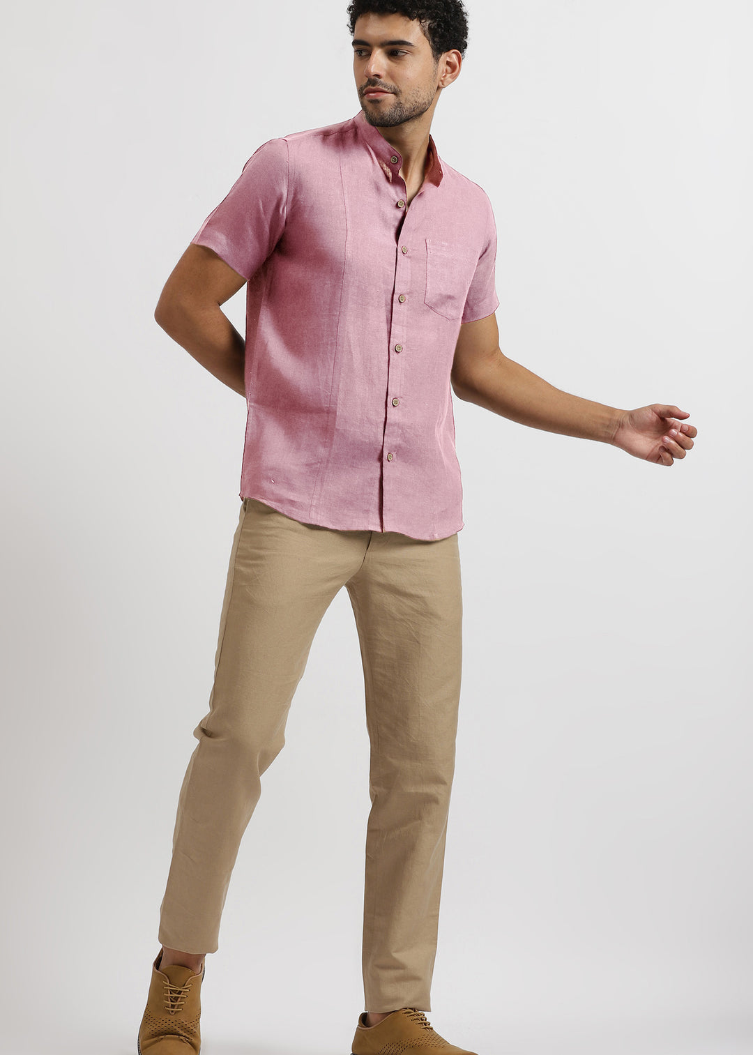Man wearing a 100% pure linen hermosa pink shirt and light hazelnut brown pants on a white background