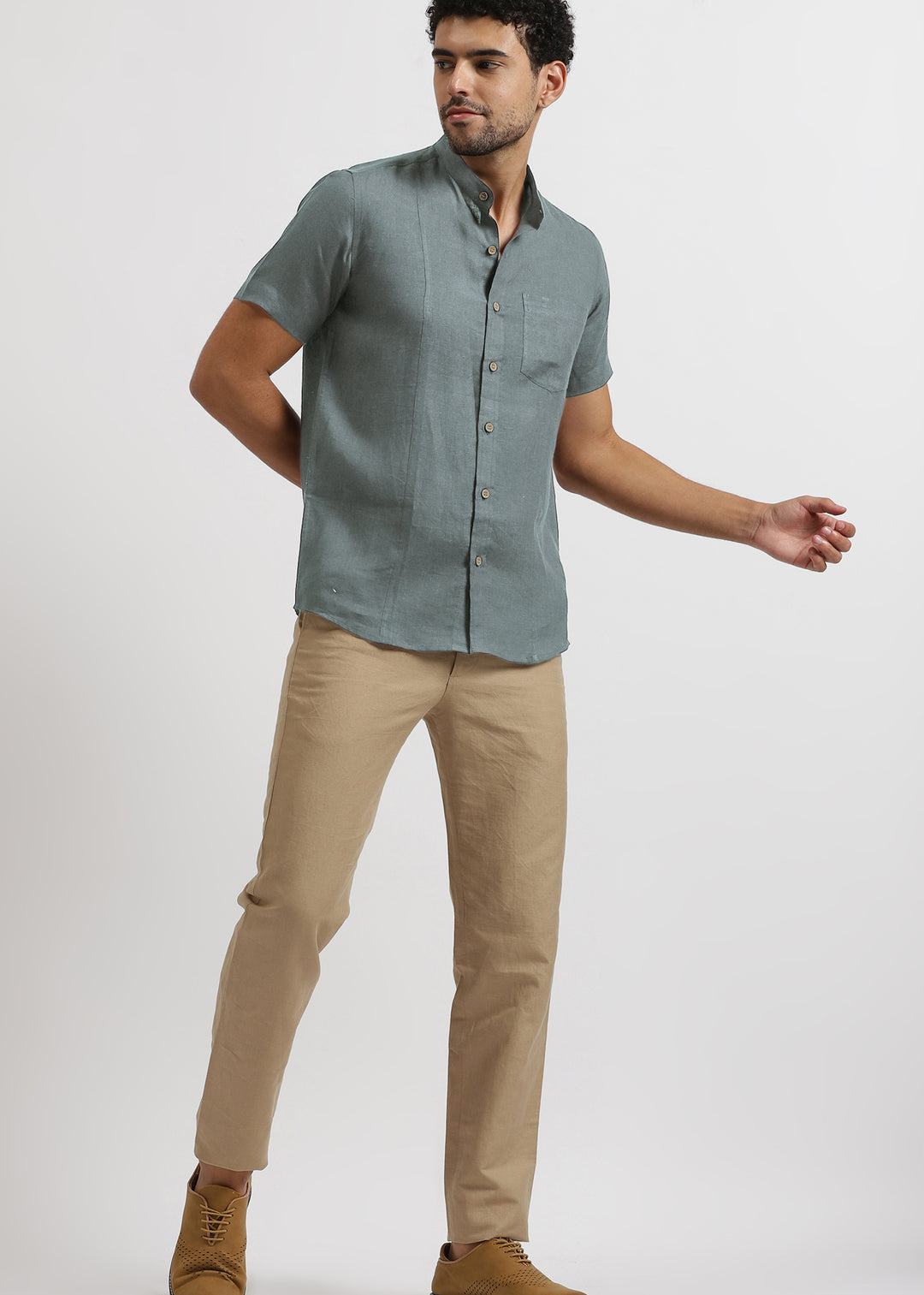 Man wearing a 100% pure linen mineral grey shirt and light hazelnut brown pants on a white background