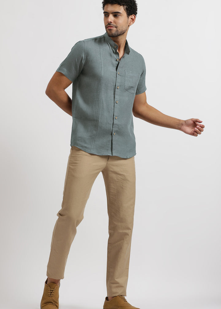 Man wearing a 100% pure linen mineral grey shirt and light hazelnut brown pants on a white background