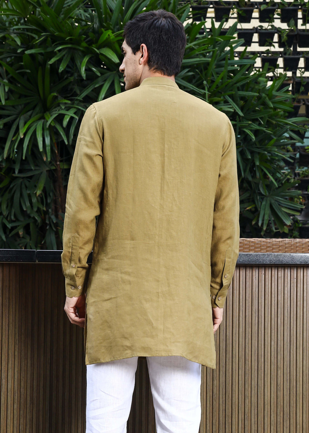 Man wearing a 100% pure linen 60 LEA sunburst yellow kurta against a green leafy background