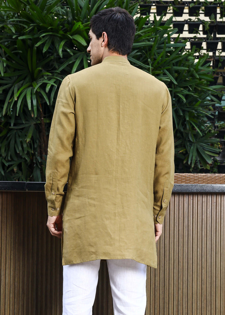Man wearing a 100% pure linen 60 LEA sunburst yellow kurta against a green leafy background