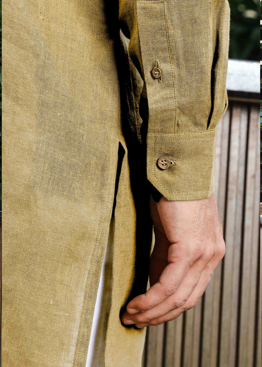 Man wearing a 100% pure linen 60 LEA sunburst yellow kurta against a green leafy background
