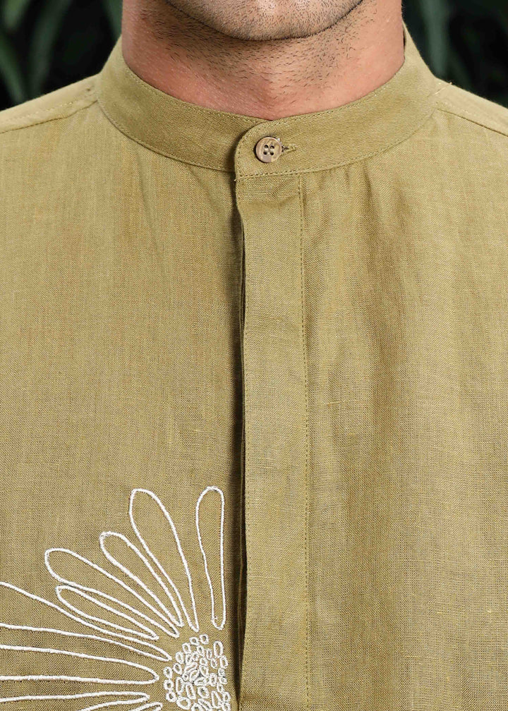 Man wearing a 100% pure linen 60 LEA sunburst yellow kurta against a green leafy background