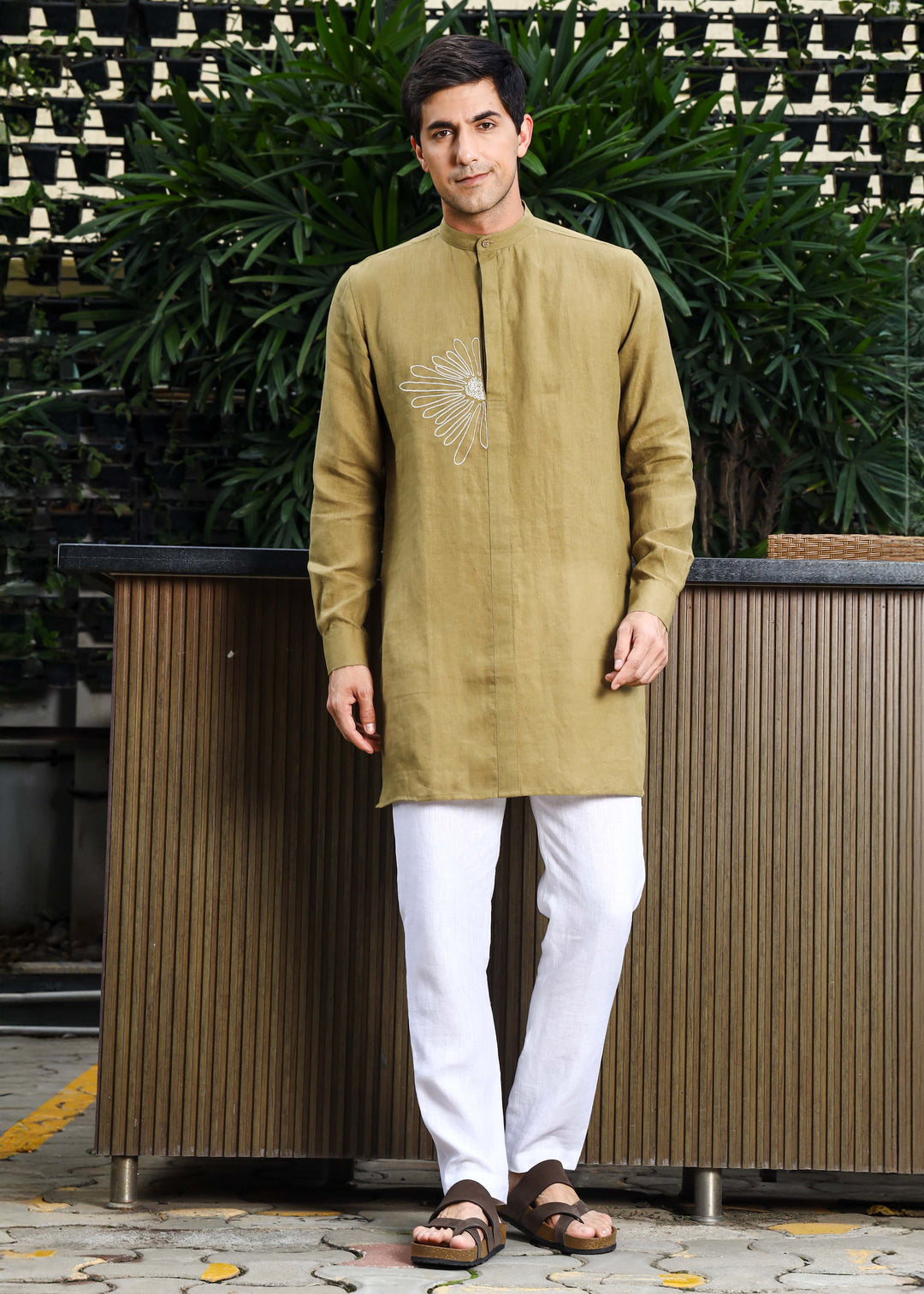 Man wearing a 100% pure linen 60 LEA sunburst yellow kurta against a green leafy background